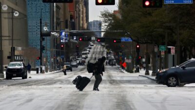 Hombre camina sobre calle congelada en EU