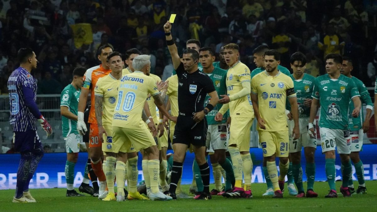 Árbitro Fernando Hernández sacando una tarjeta amarilla durante el partido entre América y León
