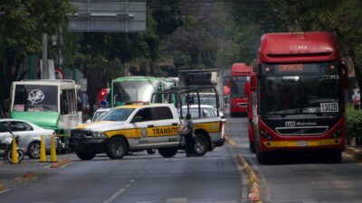 Marchas CDMX, patrulla bloqueando avenida, con un Metrobús a un lado